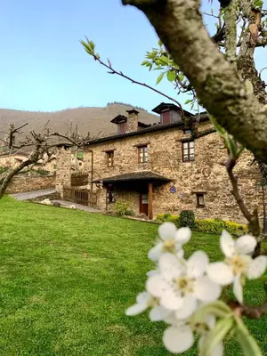 a stone house with white flowers in front of it at Casa Ponce in Posada de Rengos