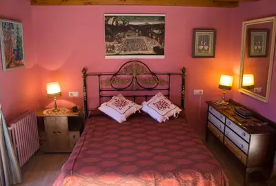 a bedroom with a bed with pink walls and two lamps at CASA CASTAÑÉ in Puente de Domingo Flórez