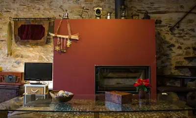 a living room with a fireplace and a table at CASA CASTAÑÉ in Puente de Domingo Flórez