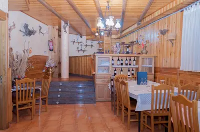 a dining room with tables and chairs and a chandelier at Hostal Tribal in Puebla de Sanabria