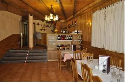a dining room with a table and chairs and a staircase at Hostal Tribal in Puebla de Sanabria