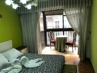 a bedroom with a bed and a view of a balcony at Piso Ourense Bonito y Termal in Ourense