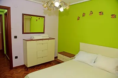 a green bedroom with a bed and a mirror at Piso Ourense Bonito y Termal in Ourense