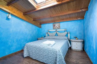 a blue bedroom with a bed and a wooden ceiling at Luxury Valdeorras in Valdegodos