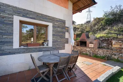 a wooden table and chairs on a patio at Luxury Valdeorras in Valdegodos