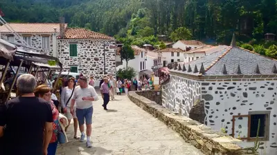 a group of people walking down a street in a village at Stone Cottage FINISTERRE in Curtis