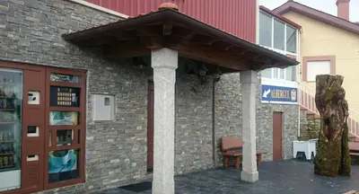 a building with an awning on the side of it at Albergue Restaurante Casa Herminia in El Campiello
