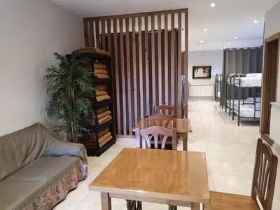 a living room with a couch and a table at Albergue Restaurante Casa Herminia in El Campiello
