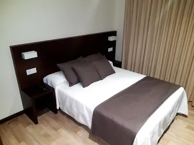a bedroom with a large bed with a wooden headboard at Complejo O Piñeiral A Fonsagrada in Fonsagrada