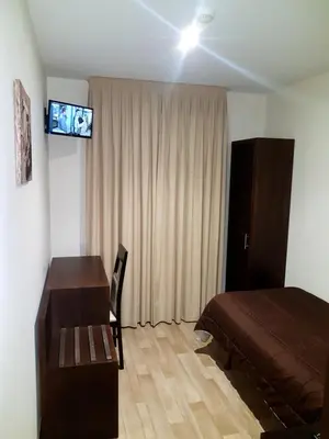a bedroom with a bed and a desk and a television at Complejo O Piñeiral A Fonsagrada in Fonsagrada