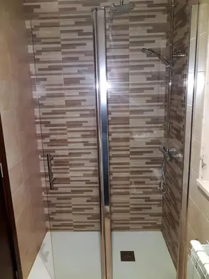 a shower with a glass door in a bathroom at Complejo O Piñeiral A Fonsagrada in Fonsagrada