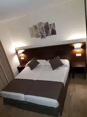 a bedroom with a large bed and two night stands at Complejo O Piñeiral A Fonsagrada in Fonsagrada