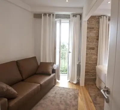 a living room with a couch and a window at Catedral Site by Como en Casa in Santiago de Compostela