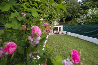 a yard with pink flowers and a fence at Catedral Site by Como en Casa in Santiago de Compostela