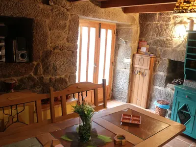 a living room with a wooden table and a window at Bodega rural tipo loft in Ourense