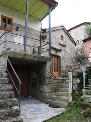 a stone house with a staircase leading to a door at Bodega rural tipo loft in Ourense
