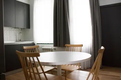 a kitchen with a white table and chairs at Lux Apartamentos Rosalia in Santiago de Compostela