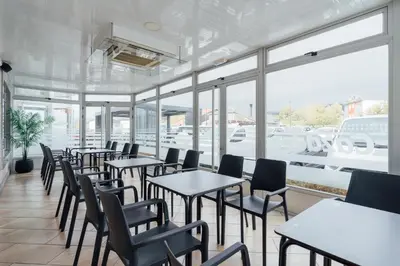 a row of tables and chairs in a restaurant with windows at Hotel Restaurante Cazador in Pereiro