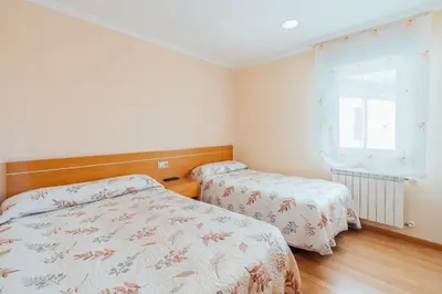 a bedroom with two beds and a window at Hotel Restaurante Cazador in Pereiro