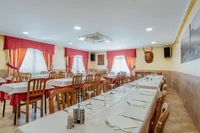 a dining room with tables and chairs and red curtains at Hotel Restaurante Cazador in Pereiro