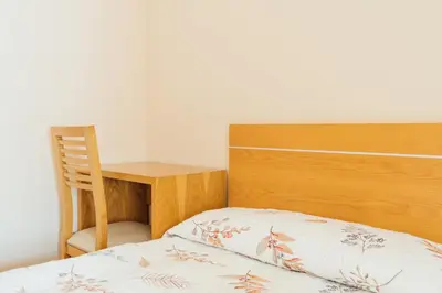 a bed with a wooden headboard next to a desk at Hotel Restaurante Cazador in Pereiro