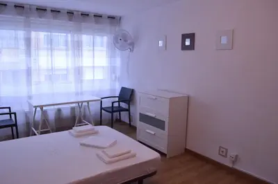 a white room with a desk and a table with chairs at ArArAt Hostel in Santiago de Compostela