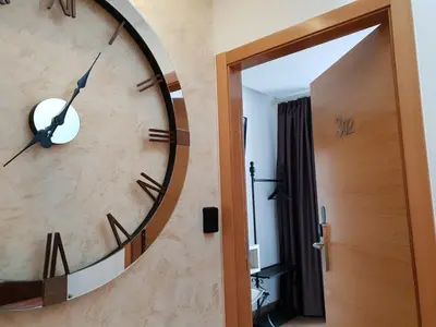 a large clock on a wall next to a door at Casa da Balconada in Santiago de Compostela