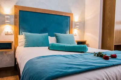 a large bed with blue sheets and red roses on it at Casa da Balconada in Santiago de Compostela