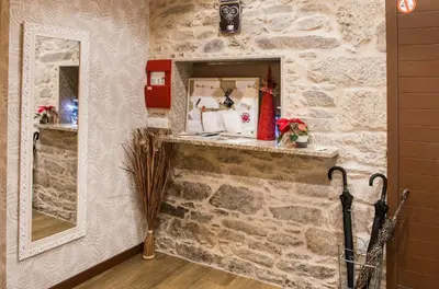 a room with a stone wall with a mirror at Casa da Balconada in Santiago de Compostela
