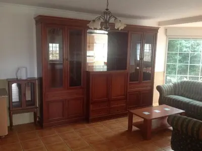 a living room with a large wooden cabinet at Casa As Pedreiras in Barreiros