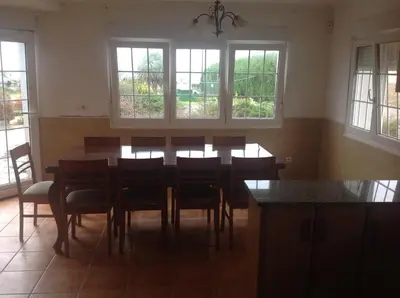 a dining room with a table and chairs and windows at Casa As Pedreiras in Barreiros