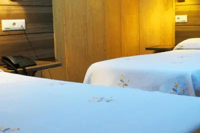 two beds with white sheets and a phone in a room at Hotel Restaurante America in Oca