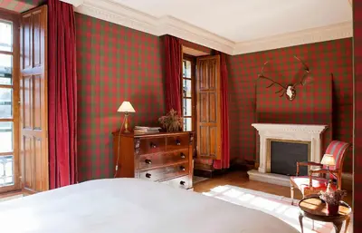a bedroom with a bed and a fireplace at Pazo de Brandeso & Country Club in Arzúa