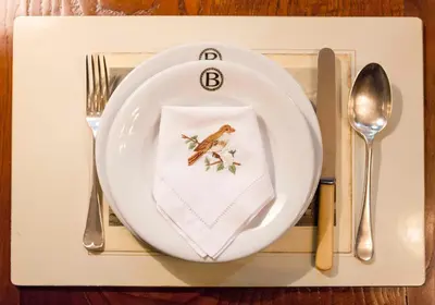 a white plate with a frog on a napkin at Pazo de Brandeso & Country Club in Arzúa