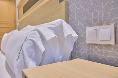 a white shirt on a hospital bed next to a lightswitch at Hotel Praza Quintana in Santiago de Compostela