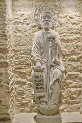 a statue of a man holding a sign on a wall at Hotel Praza Quintana in Santiago de Compostela