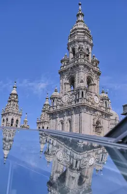 a building with a clock tower with its reflection at Hotel Praza Quintana in Santiago de Compostela