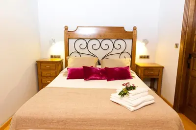 a bedroom with a large bed with red pillows at Finca Goleta in Foz