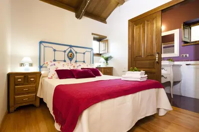 a bedroom with a large bed with a red blanket at Finca Goleta in Foz