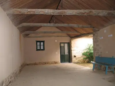 an empty room with a wooden ceiling and a green door at Casa Rural La Dama del Alba in Vega de Magaz