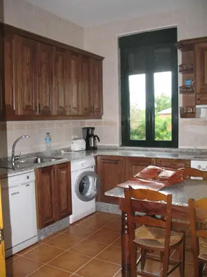 a kitchen with a sink and a washing machine at Casa Rural La Dama del Alba in Vega de Magaz
