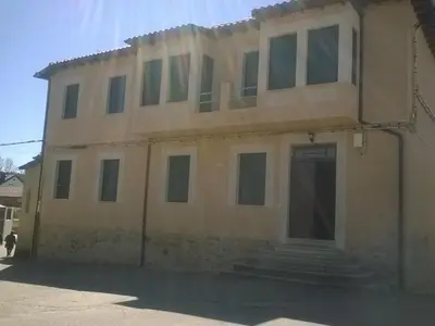 an old house with a lot of windows at Casa Rural La Dama del Alba in Vega de Magaz
