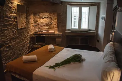 a bedroom with a large bed with greens on it at Pensión A Casa do Peregrino in Santiago de Compostela