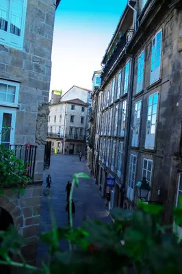a city street with buildings and people walking down a street at Pensión A Casa do Peregrino in Santiago de Compostela