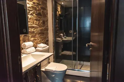 a bathroom with a shower and a toilet and a sink at Pensión A Casa do Peregrino in Santiago de Compostela