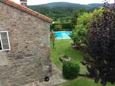 an external view of a stone house with a swimming pool at Casa Socorro in A Estrada