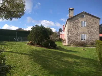 an old stone house on a grassy field at Casa Socorro in A Estrada