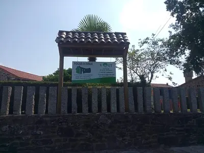 a wooden fence with a sign in front of a house at Fogar de Insua in Touro