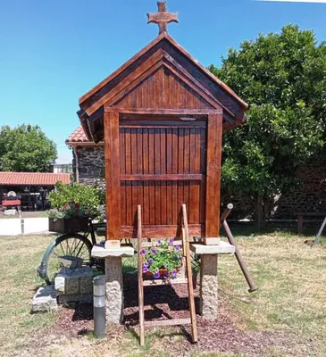 a small wooden chapel with a cross on top at Fogar de Insua in Touro