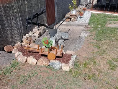 a garden with a wooden train and some rocks at Fogar de Insua in Touro